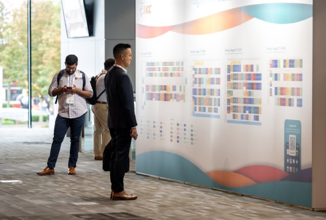 An attende looking at the program on a wall